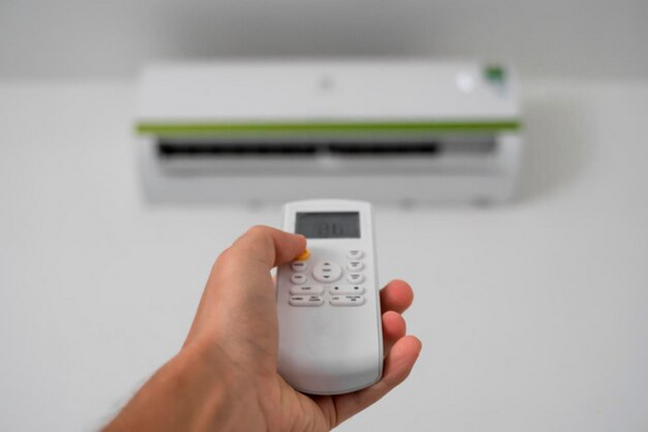 Hand holding a remote control for a split-type air conditioner