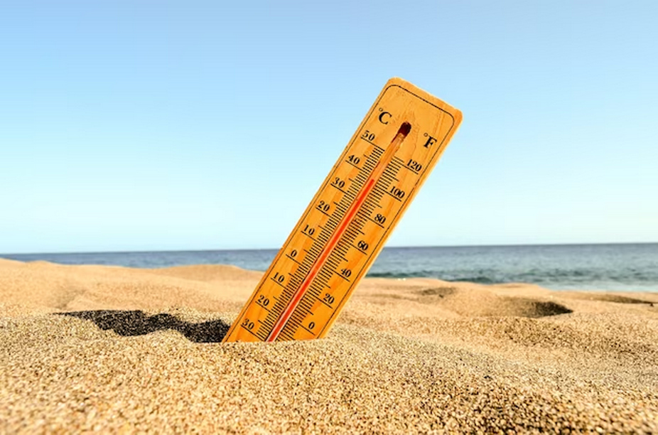 A thermometer positioned outside in the sand