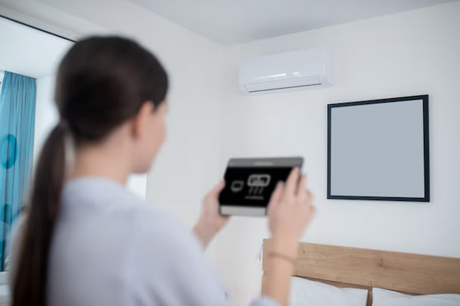 Female holding air conditioner thermostat